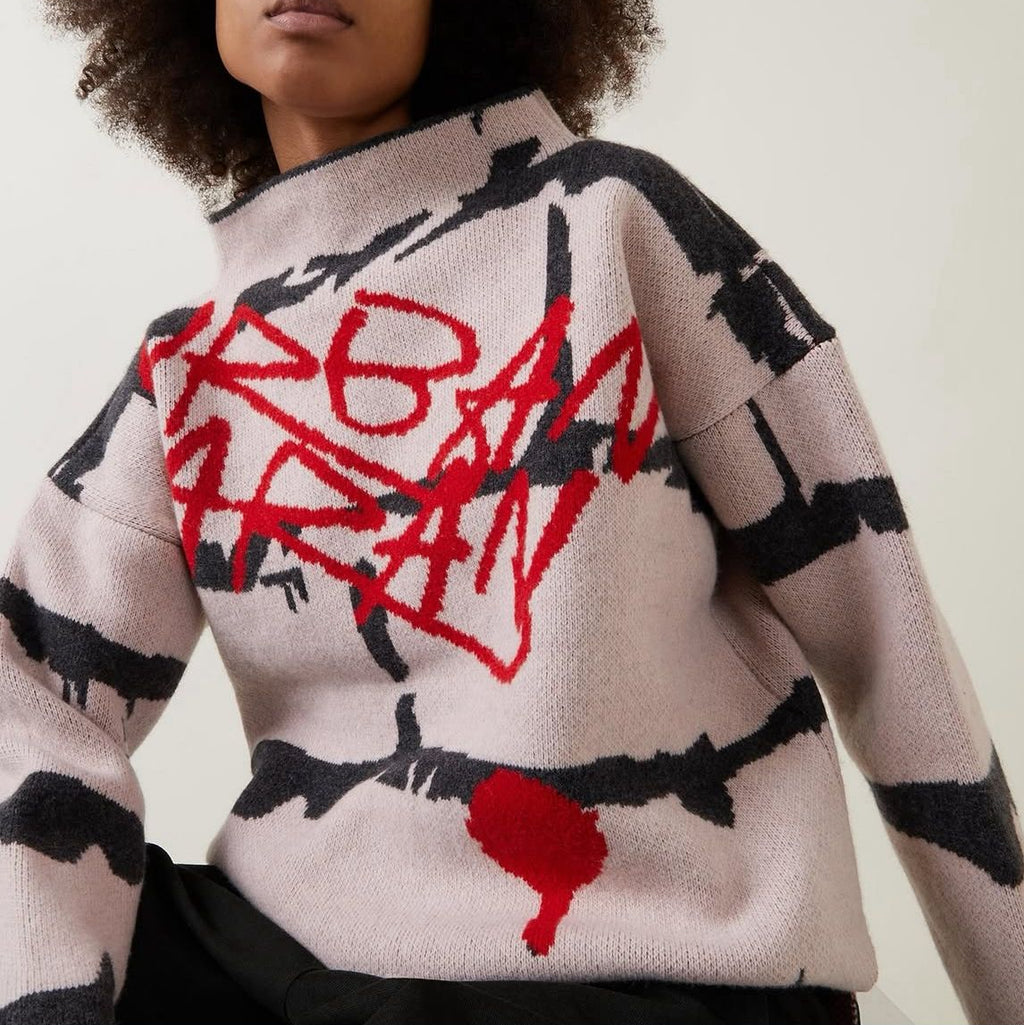 Person wearing a sweater with red and black abstract design